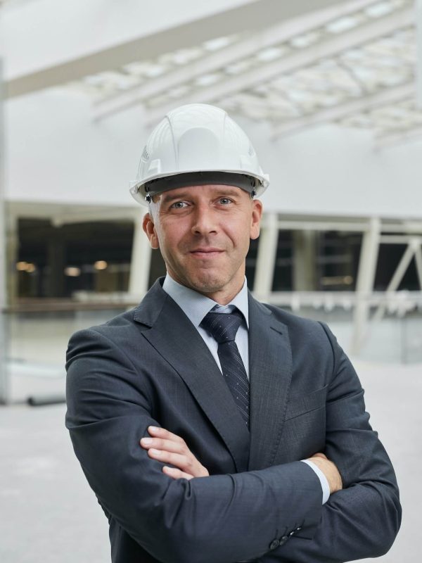 confident-businessman-at-construction-site-1-py9wpe6bcqamfrfnxih20n6tj2ze9ba6g2l8k8gksg